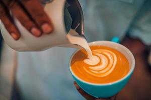 abstract koffie winkel detailopname, koffie kop latte kunst. barista maken een kop van koffie latte kunst. wijnoogst toon van sommige mensen gieten melk naar maken latte kunst koffie foto