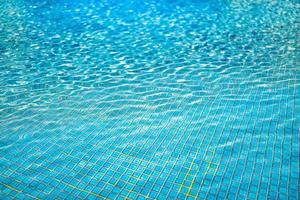 water achtergrond, rimpeling en stromen met golven. zomer blauw zwemmen zwembad patroon. zee, oceaan oppervlak. foto