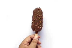 menselijk hand- Aan chocola ijs room stok en noten foto
