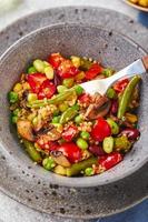 quinoa met groen bonen, tomaten, gebakken champignons, maïs, rood klok pepers, erwten en soja bonen. gezond groente mengen foto