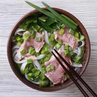 soep pho bo met rundvlees, rijstnoedels, groenten bovenaanzicht foto