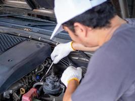 monteur die een moersleutelhandvat vasthoudt terwijl hij een auto repareert. foto