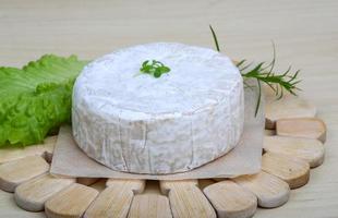 Camembert kaas Aan houten bord en houten achtergrond foto