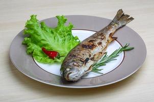 gegrilde forel op de plaat en houten achtergrond foto