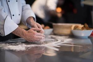 chef handen voorbereidingen treffen deeg voor pizza foto