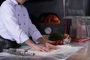 chef voorbereidingen treffen deeg voor pizza foto