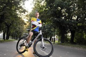 fit gelukkig jong Mens glimlachen Aan fiets foto