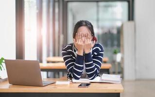 moe jong Universiteit leerling Aziatisch vrouw met benadrukt en hoofdpijn met leren online les. jong vrouw kan niet begrijpen wanneer leraar onderwijs Aan online internet door studie Bij cafe ze krijgen verveeld foto