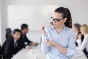 bedrijf vrouw staand met haar personeel in achtergrond foto