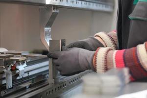 vrouw werken in een modern fabriek en voorbereidingen treffen materia voor een cnc machine. foto