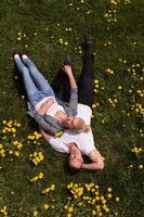 Mens en vrouw aan het liegen Aan de gras foto