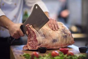 chef snijdend groot stuk van rundvlees foto