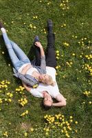 Mens en vrouw aan het liegen Aan de gras foto