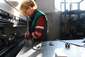 vrouw werken in een modern fabriek en voorbereidingen treffen materia voor een cnc machine. foto