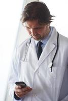 dokter sprekend Aan mobiele telefoon foto