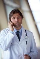 dokter sprekend Aan mobiele telefoon foto