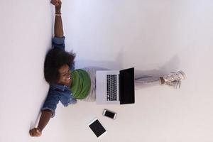 Afrikaanse Amerikaans vrouw zittend Aan verdieping met laptop top visie foto