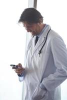 dokter sprekend Aan mobiele telefoon foto