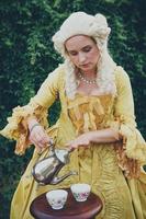 portret van blond vrouw gekleed in historisch barok kleren met oud mode kapsel, buitenshuis. foto