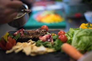 chef hand- afwerking steak vlees bord foto