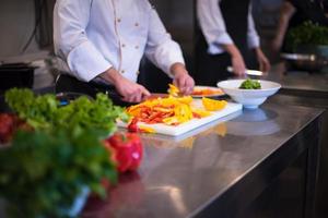 chef snijdend vers en heerlijk groenten foto