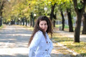 brunette schattig jong vrouw glimlachen buitenshuis in natuur foto