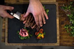 top visie van chef handen portie rundvlees steak foto