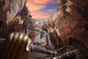 oude Boeddhabeeld tegen schemering hemel in Sukhothai foto