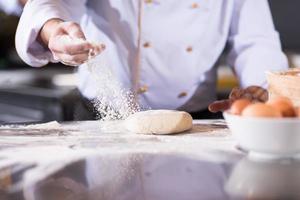 chef handen voorbereidingen treffen deeg voor pizza foto