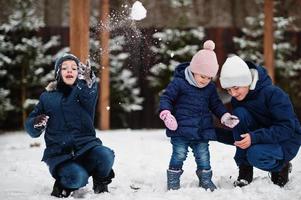 drie kinderen spelen in de winterdag. broers met jongste zus. foto