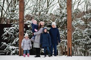 aantrekkelijke moeder met haar vier kinderen in de winterdag. foto