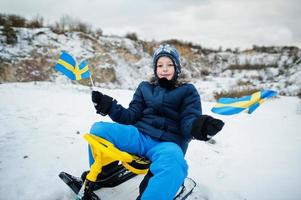 scandinavische jongen met de vlag van zweden in de winter zweeds landschap. foto