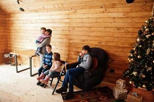 moeder en kinderen in modern houten huis met Kerstmis boom, uitgeven tijd samen in warm en liefde. foto