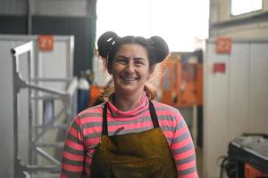 een portret van een Dames lasser Holding een helm en voorbereidingen treffen voor een werken dag in de metaal industrie foto