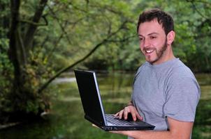 jong zakenman met laptop buitenshuis foto