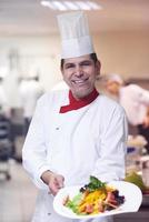 chef in hotel keuken voorbereidingen treffen en decoreren voedsel foto