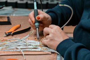 industrieel arbeider vrouw solderen kabels van fabricage uitrusting in een fabriek foto