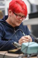 industrieel arbeider vrouw solderen kabels van fabricage uitrusting in een fabriek foto