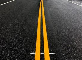 asfalt weg met geel lijnen in de avond van de dag met leeg auto's, zacht en selectief focus. foto