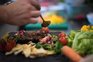 chef hand- afwerking steak vlees bord foto