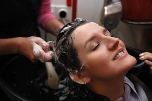 mooi jong vrouw genieten van een haar wassen foto