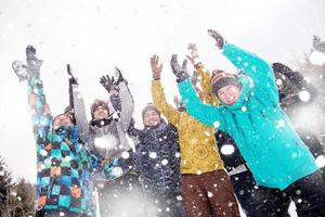 groep van jong mensen het werpen sneeuw in de lucht foto