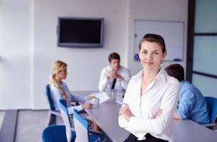 zakenvrouw met haar personeel op achtergrond op kantoor foto