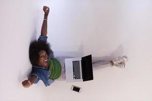 Afrikaanse Amerikaans vrouw zittend Aan verdieping met laptop top visie foto