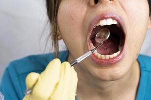 jong vrouw tandarts Holding tandheelkundig instrumenten in haar hand- foto