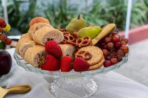 glas fruit mand, picknicken buiten. uit van focus vegetatie in de achtergrond. foto