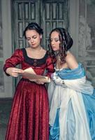 mooie meisjes in middeleeuwse jurken met scroll letter foto