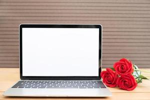 rood roos en laptop mockup Aan hout foto