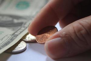 man's hand- plukken omhoog cent of cent munt van een stapel van bankbiljetten en munten. foto