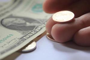man's hand- plukken omhoog cent of cent munt van een stapel van bankbiljetten en munten. foto